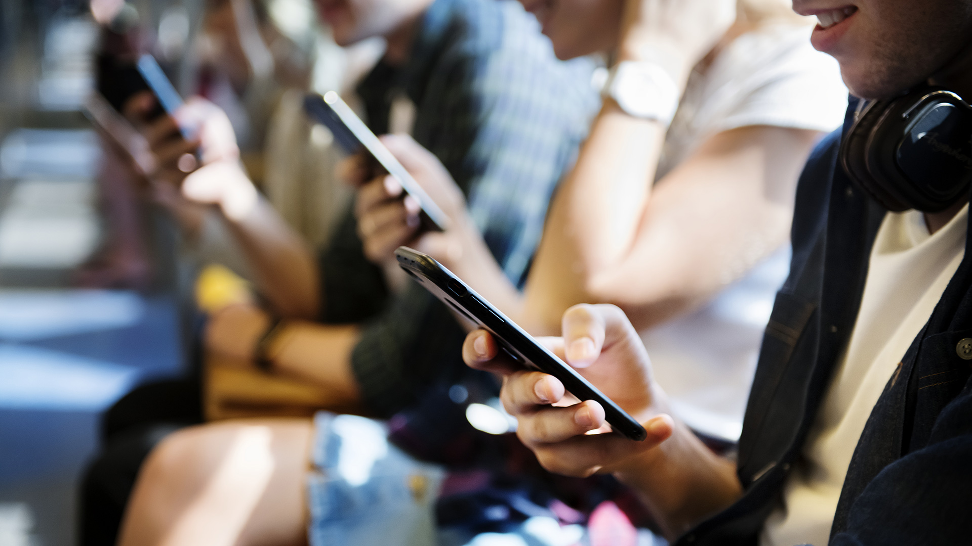 Mensen-zittend-met-mobiele-telefoon-in-de-hand-16-9