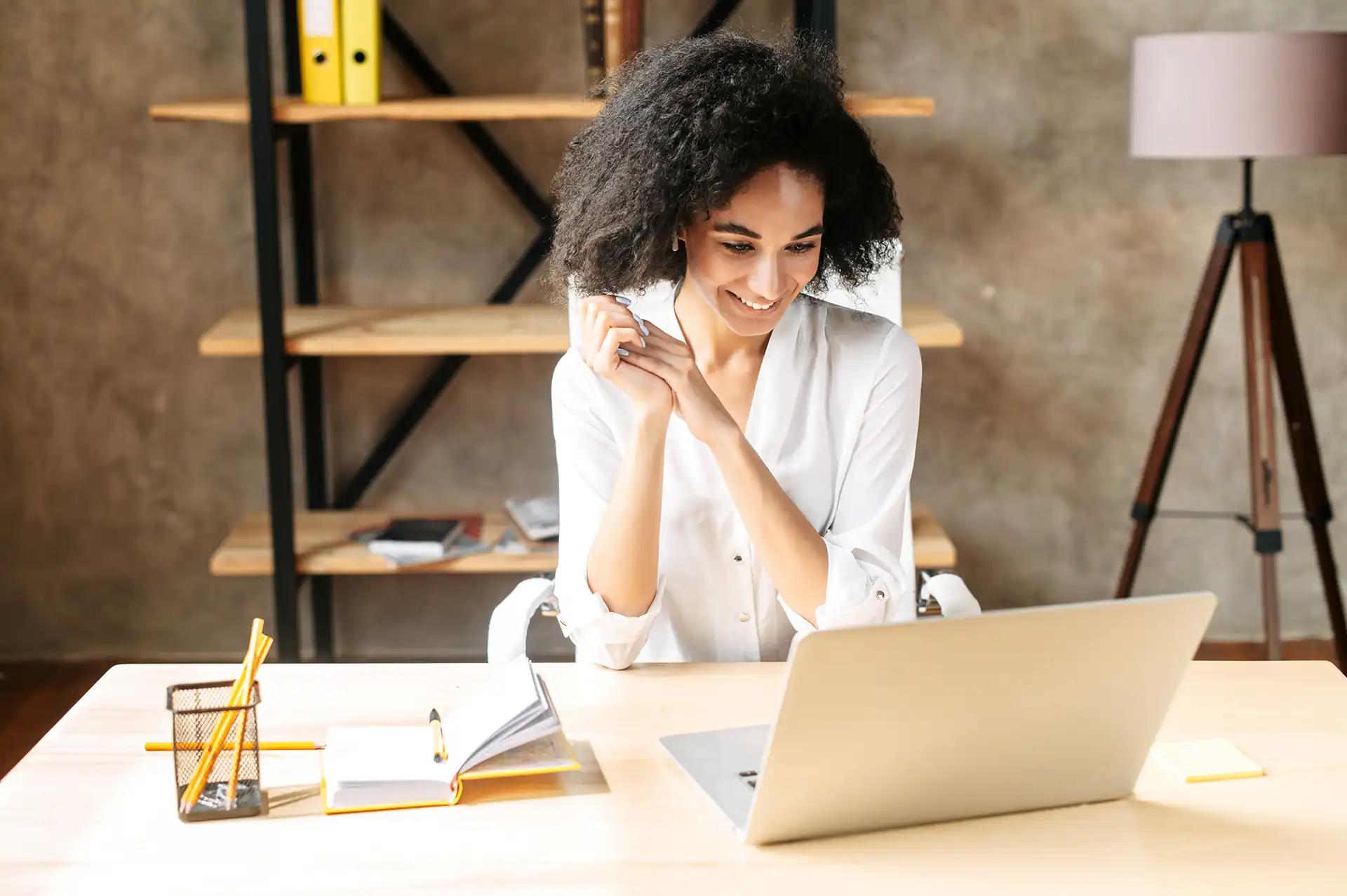 Vrouw kijkt blij naar laptop (AdobeStock_383816173)