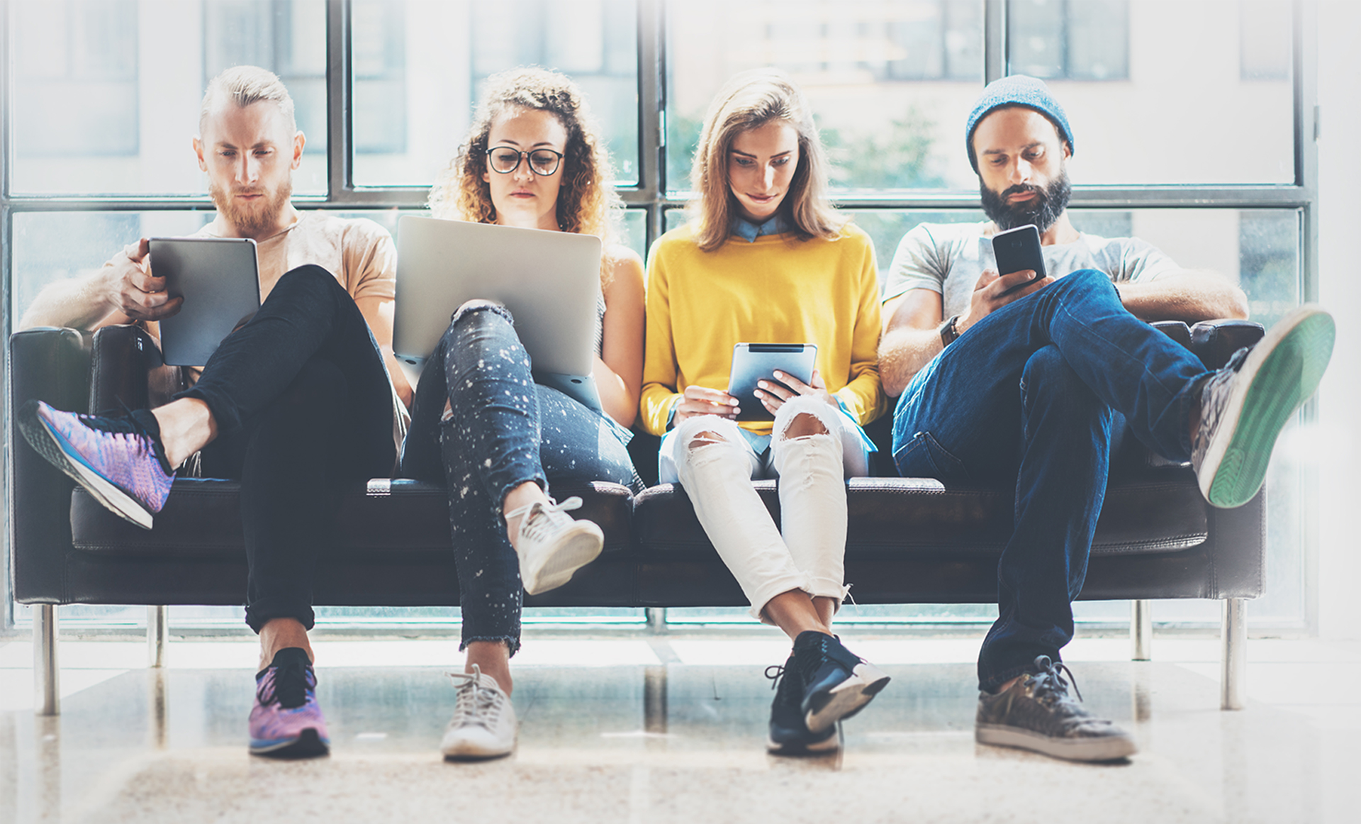 Jongeren op een bankje die informatie op internet lezen.