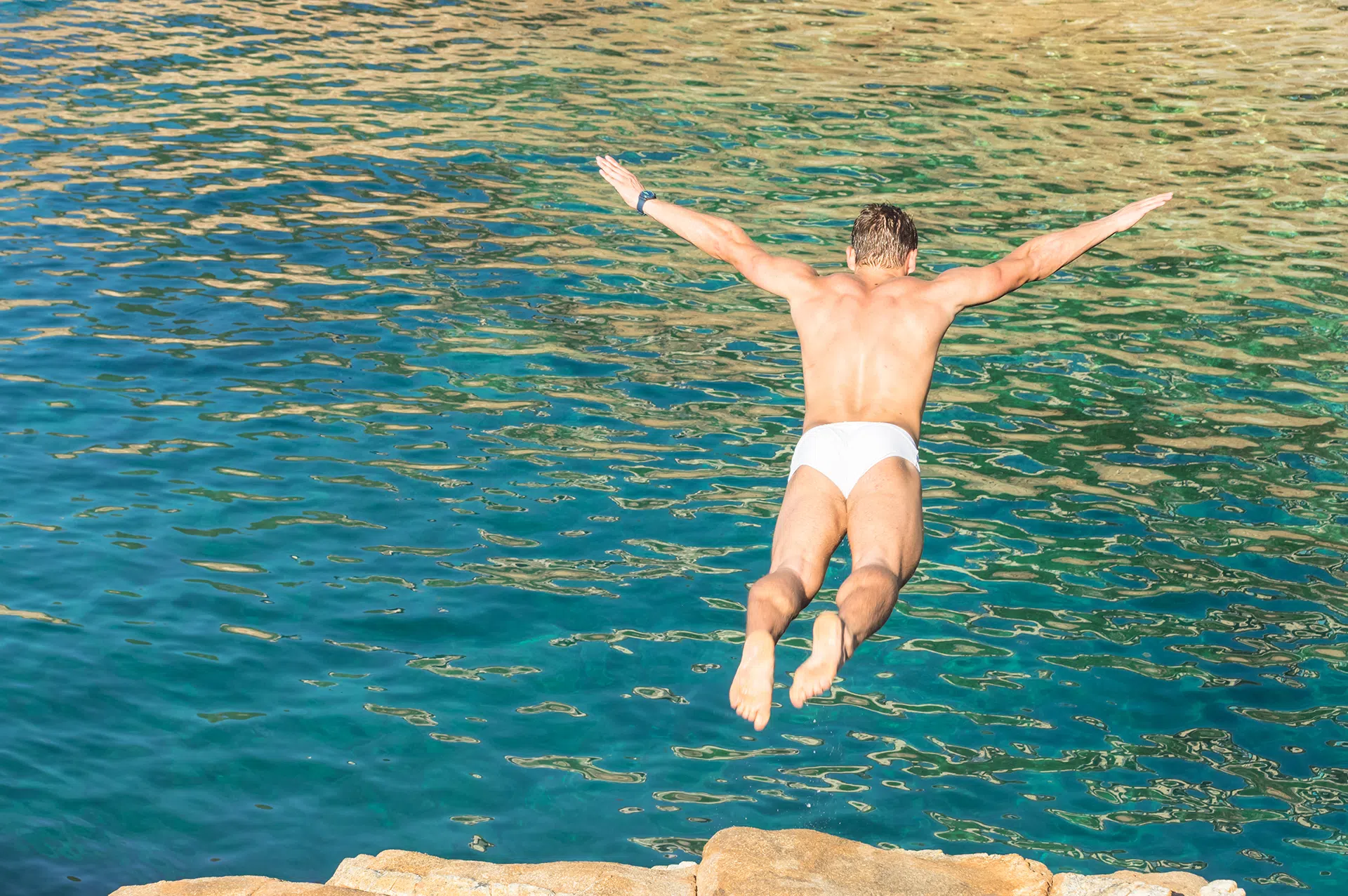 Man springt in zeewater van rotsen maar heeft wel zich wel beveiligd tegen cyberdreigingen!